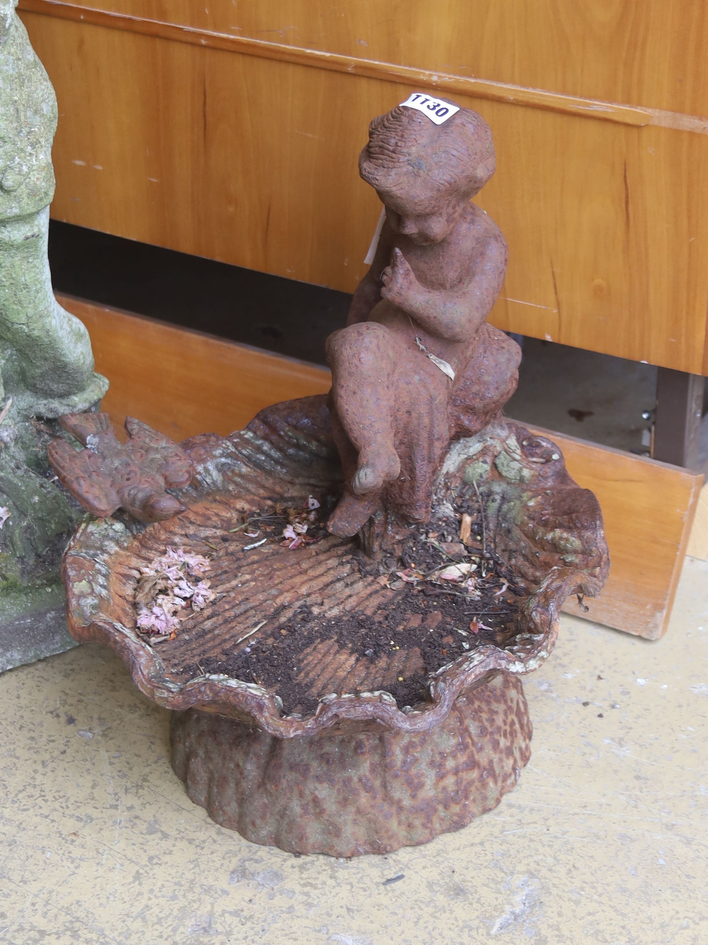 A cast iron scallop shell and figural bird bath, width 34cm, height 40cm